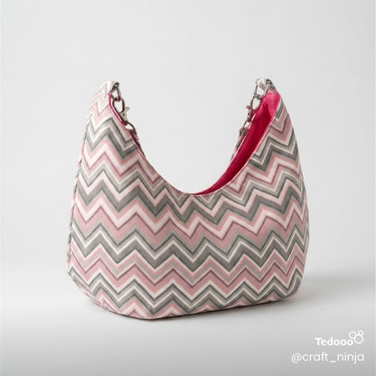Pink, white and gray zigzag patterned handbag with a bright pink interior  on a light gray background