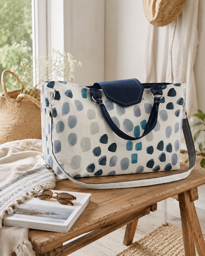 Patterned tote bag on a wooden bench with books and sunglasses