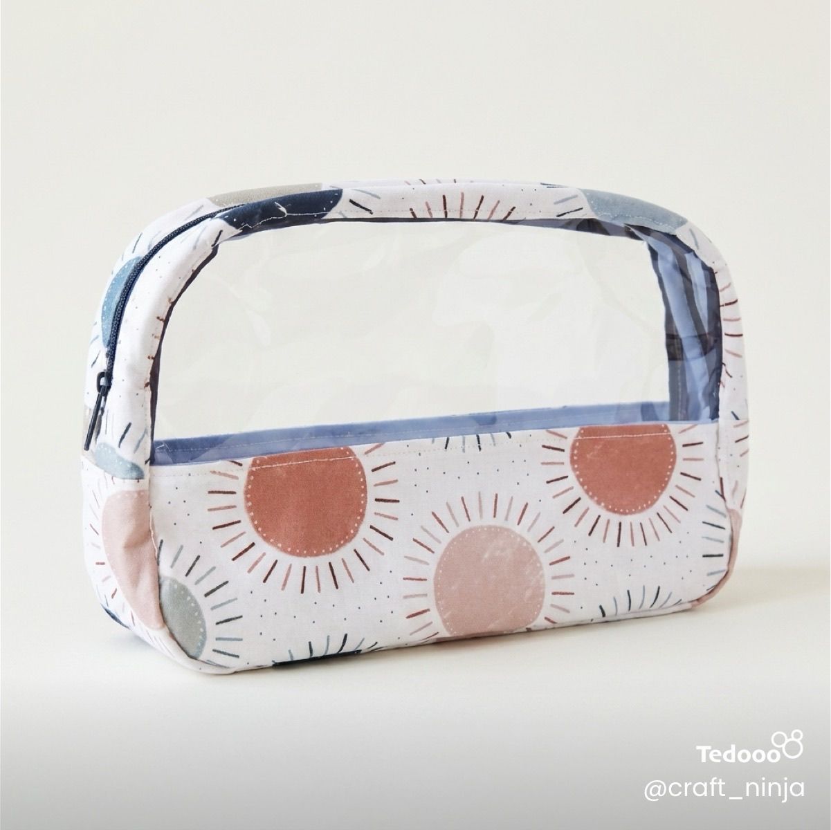 Rectangular vinyl and fabric zip pouch with geometric circular pattern.